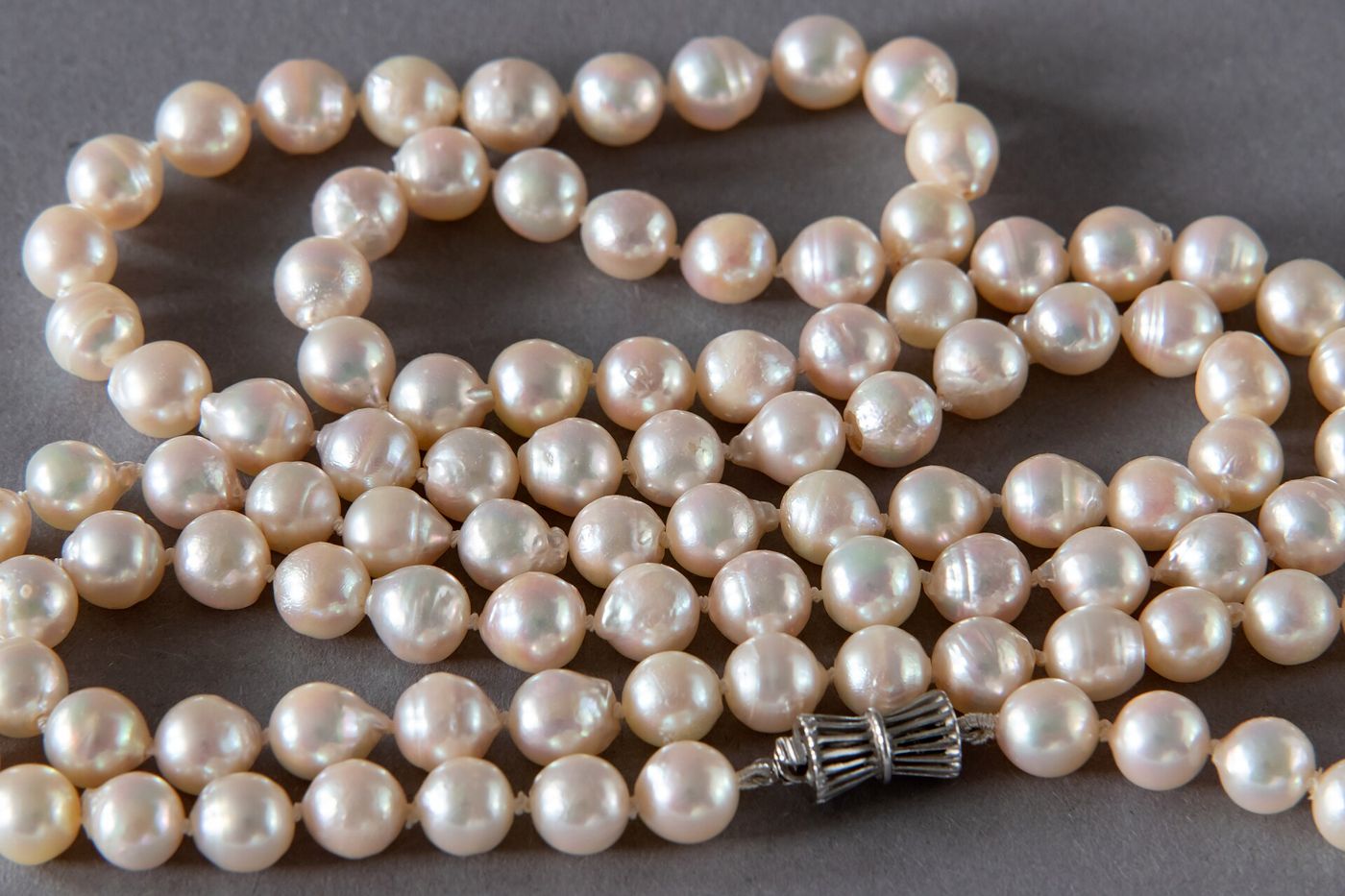 Collar de perlas sobre una tela gris